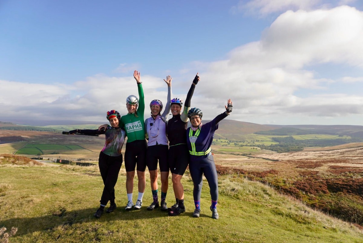 Five riders cheering on a moorland summit