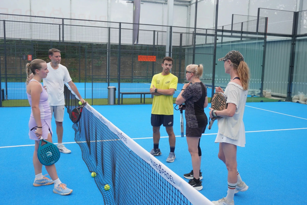 A theKlub host briefing a group on court before a session